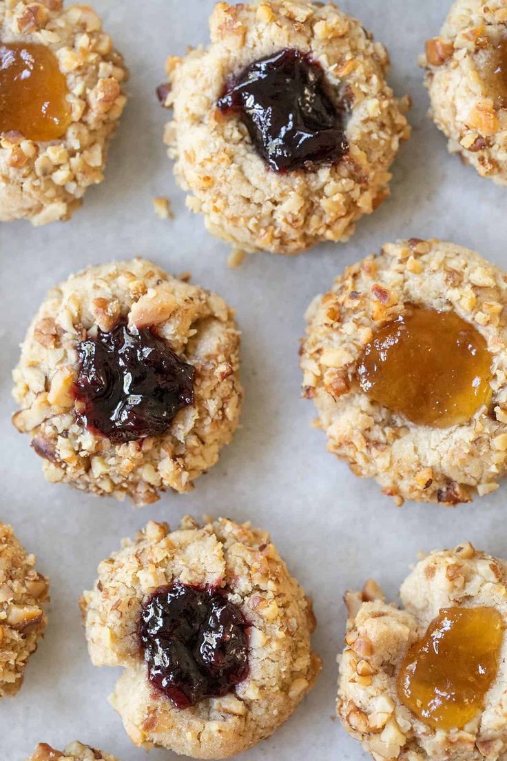 an assortment of cookies with jam on top and oatmeal in the middle