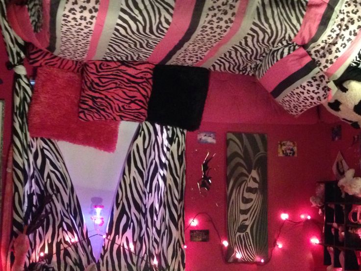 a bedroom decorated with zebra print and pink lights