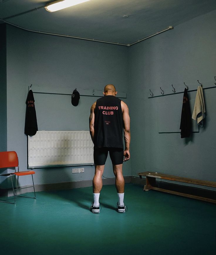 a man standing in a gym with his back to the camera