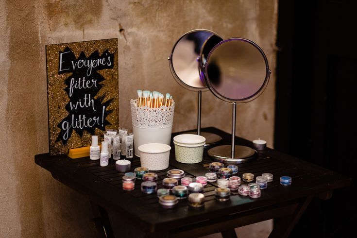 a table topped with lots of candles next to a mirror and other items on top of it