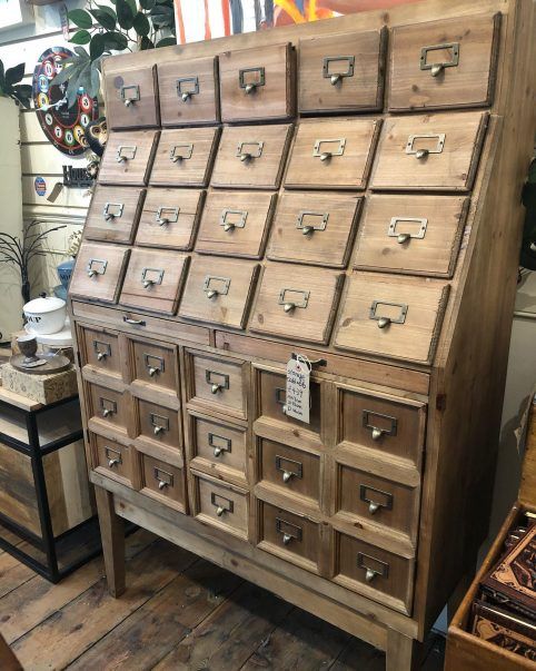 an old wooden dresser with lots of drawers on it's sides in a store