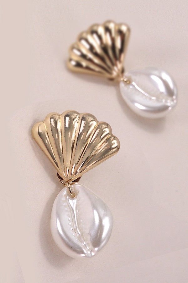 Crafted with care, these earrings feature delicate seashells and authentic puka shells dangling gracefully from each ear. Inspired by the serene allure of the ocean, they infuse your ensemble with a touch of seaside elegance. Perfect for adding a hint of beachy flair to any outfit, whether you're vacationing by the shore or simply longing for coastal vibes. Product Details:Width: 1"Length: 1.5"Earring back: PostMetal finish: gold, rhodium PlatedProduct: Lead & Nickel CompliantAnti-tarnish: Double E-coating Elegant Shell Dangle Earrings, Elegant Shell Dangle Jewelry, Elegant Dangle Shell Earrings, Elegant Dangle Shell, Elegant Teardrop Shell Jewelry, Elegant Drop Earrings For Vacation, Dangle Shell Earrings With Pearl Drop, Dangle Pearl Drop Shell Earrings, Elegant Shell-shaped Earrings For Vacation