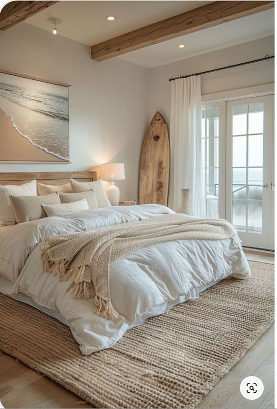 a bedroom with a surfboard on the wall next to it and a large bed in front of a sliding glass door