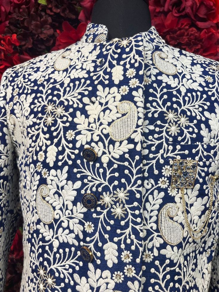 Step into sophistication with the Hardik Sherwani, a perfect blend of tradition and modern style. This navy blue sherwani, adorned with intricate white floral embroidery, exudes luxury and refinement, ideal for grooms or special occasions. Key Features: Elegant Design: Navy blue base with detailed white floral embroidery. High Collar: Adds a touch of classic elegance. Premium Quality Fabric: Ensures comfort and a perfect fit. Ideal for Weddings & Celebrations: Perfect for making a memorable stat Designer Blue Kurta With Intricate Embroidery, Traditional Blue Kurta With Floral Print, Traditional Blue Nehru Jacket With Intricate Embroidery, Designer Blue Nehru Jacket With Traditional Drape, Traditional Nehru Jacket With Floral Print For Designer Wear, Designer Blue Traditional Wear For Reception, Festive Designer Sherwani With Floral Embroidery, Blue Chikankari Embroidered Nehru Jacket For Reception, Designer Blue Traditional Wear For Festive Season