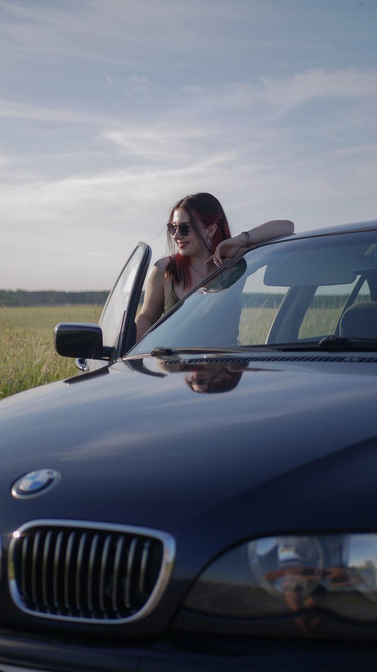 a woman leaning out the window of a car