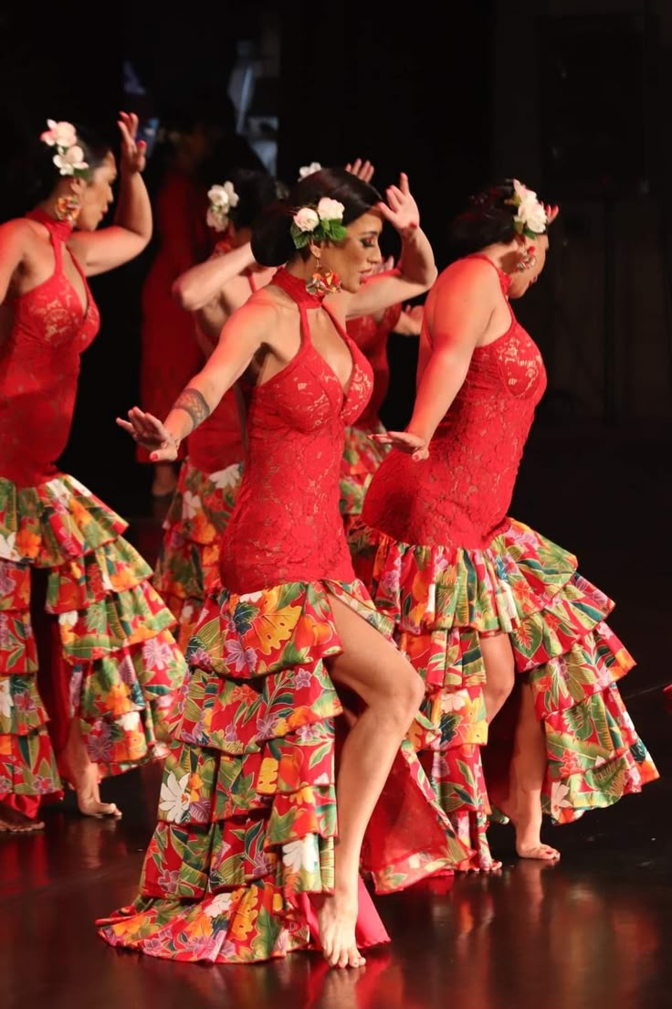 a group of women in red dresses dancing on stage