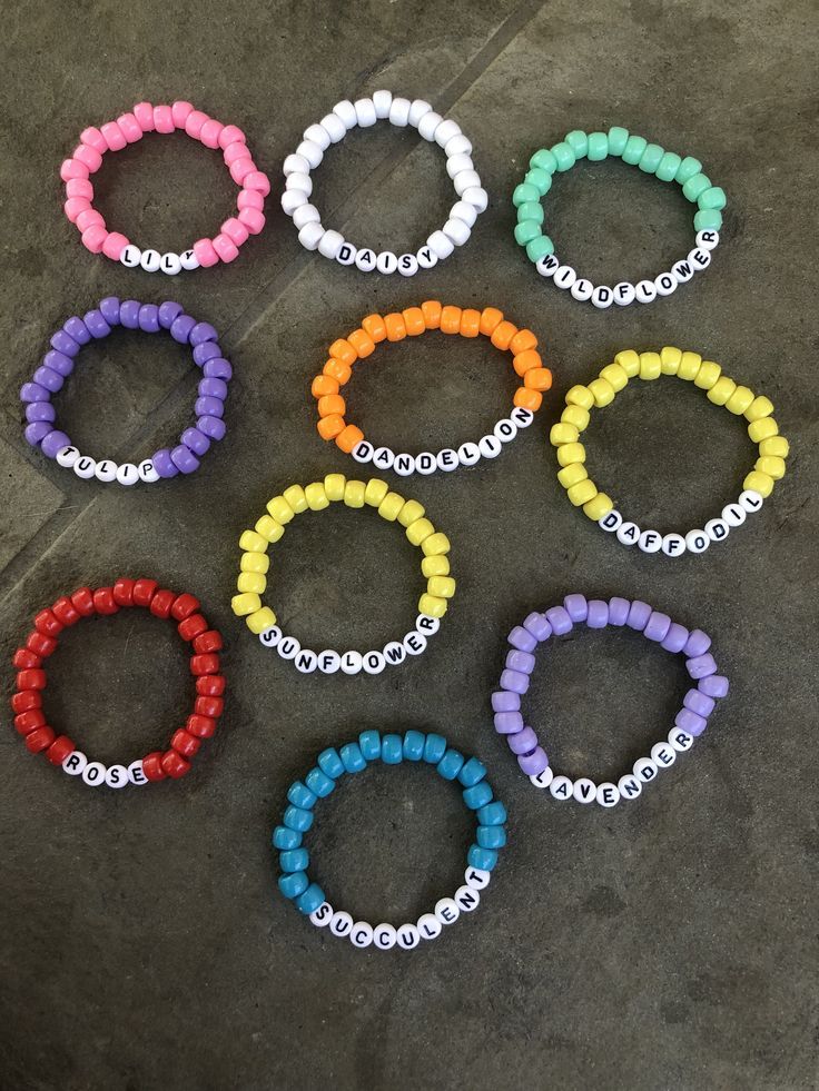 six bracelets with different colors and sizes are arranged on the concrete floor next to each other