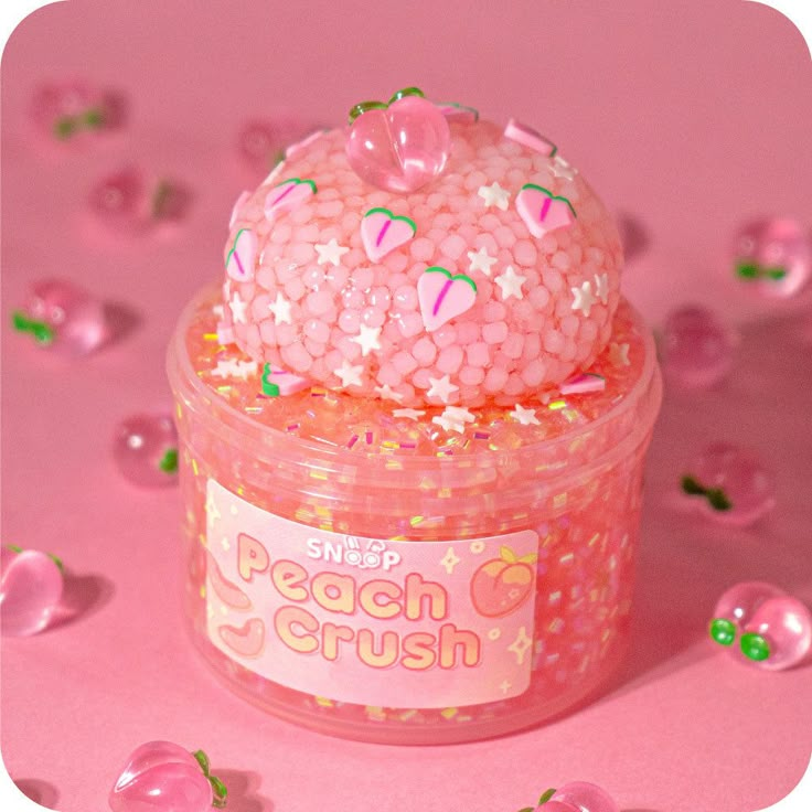 a small jar filled with pink gummy bears and sprinkles on a pink surface