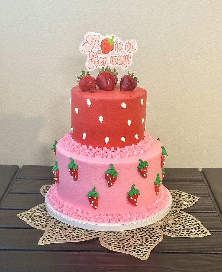 a three tiered cake with strawberries on top