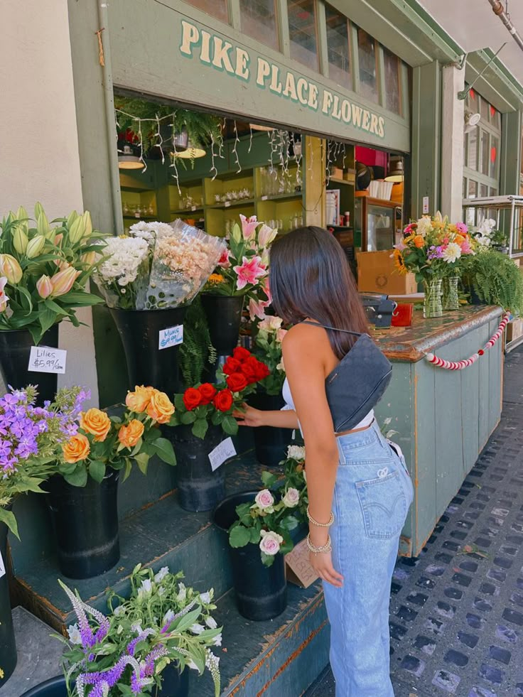 a woman standing in front of a flower shop