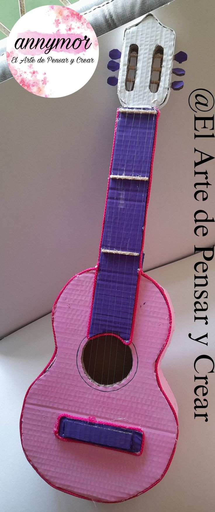 a pink and purple ukulele sitting on top of a table