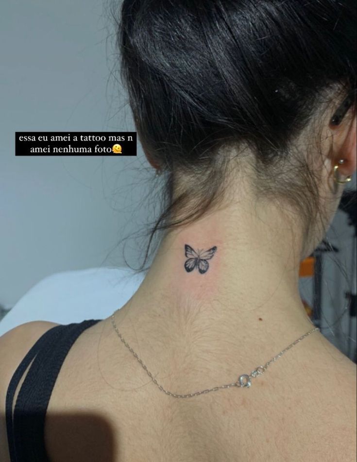 a woman with a small butterfly tattoo on her neck