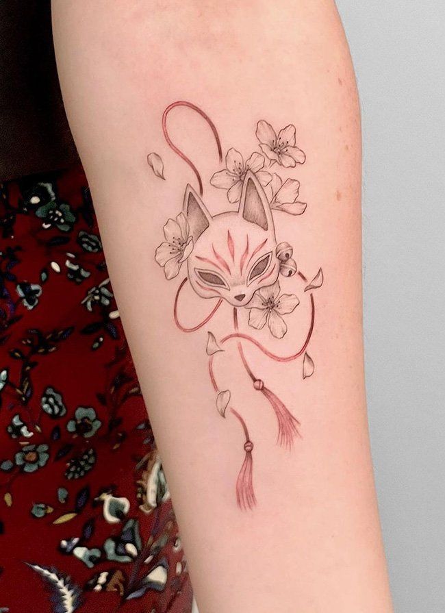 a woman's arm with a tattoo on it that has an image of a cat and flowers