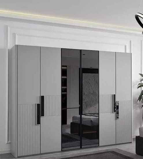 an image of a bedroom with white closets and black glass doors in the corner