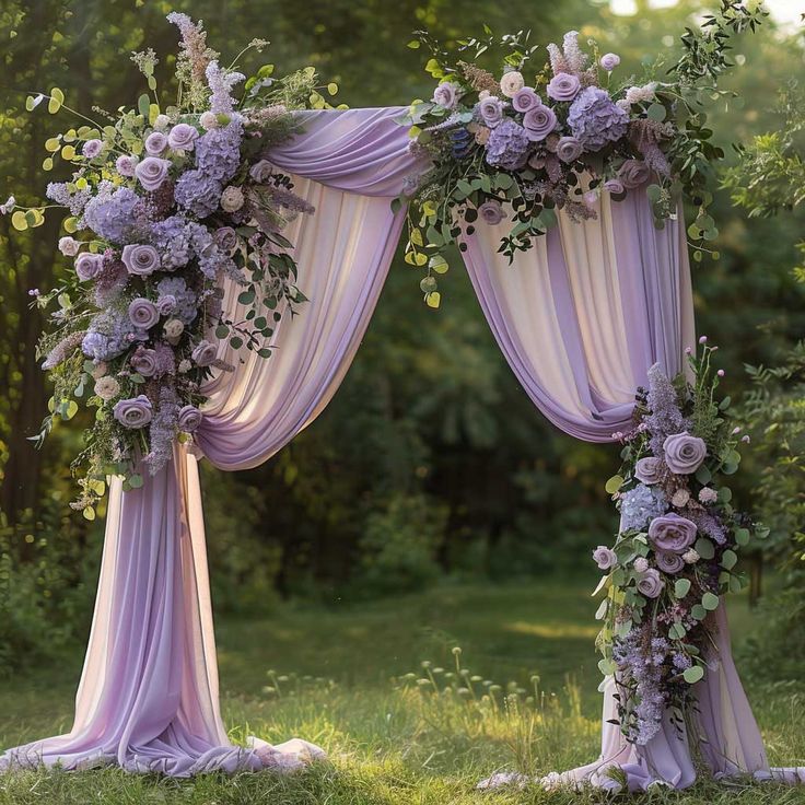 an outdoor wedding arch decorated with purple flowers and greenery