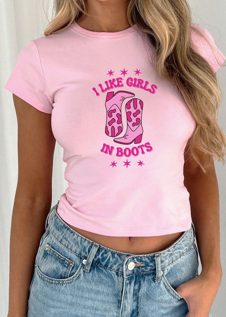 Show off your pride and Western flair with our super cute baby tee, perfect for all the cowgirl-loving gals out there! 🤠💖 This tee features the playful phrase "I Like Girls in Boots" alongside an adorable pair of cowboy boots. Whether you're out on the ranch or just want to add a touch of country charm to your everyday style, this Y2K-inspired crop top is a must-have. Embrace your love for girls and boots with a tee that's as stylish as it is proud! 🌈✨ MaterialInformation: - 100% midweight US Trendy Pink Short Sleeve Crop Top, Pink Tops With Funny Text For Spring, 90s Inspired Tops With Funny Print For Spring, Cute Fitted T-shirt With Text Print, Trendy Pink Tops With Funny Text, Trendy Fitted Tops With Funny Print, 90s Inspired Funny Print Tops For Spring, 90s Inspired Short Sleeve Tops With Funny Print, Spring Tops With Funny Print In 90s Style