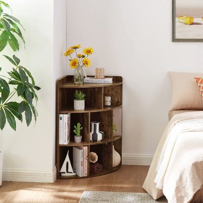 a bedroom with a bed, plant and bookshelf on the floor in front of it