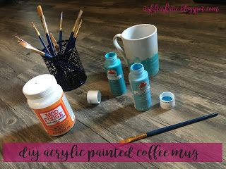 some paint bottles and brushes on a wooden floor with the words diy acrylic painted coffee mugs