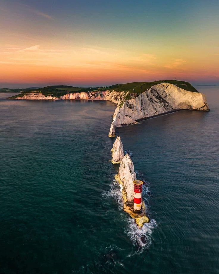 an aerial view of the lighthouses in the ocean at sunset, with white cliffs and blue water