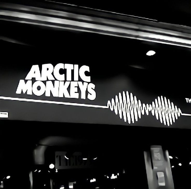 the arctic monkeys sign is lit up in black and white with sound waves on it