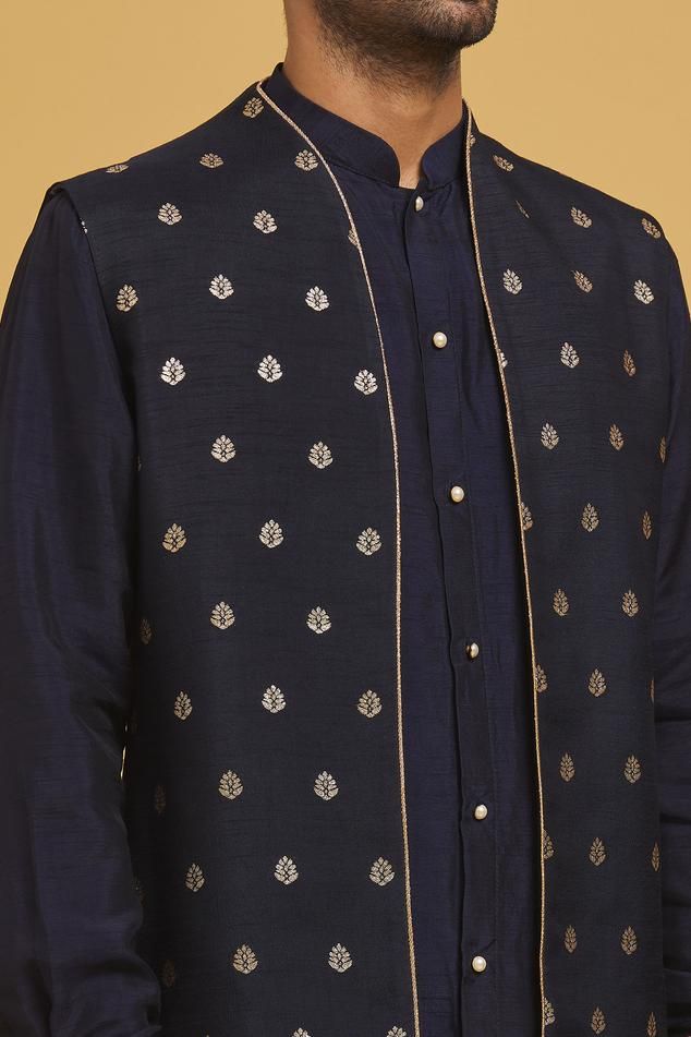 Navy blue silk nehru jacket with floral motifs applique embroidery. Comes with off-white cotton silk straight pant and a kurta.
Components: 3
Pattern: Applique embroidered
Type Of Work: Floral motifs
Neckline: Mandarin collar
Sleeve Type: Nehru Jacket: Sleeveless, Kurta: Full
Fabric: Silk, Pant: Cotton silk
Color: Blue
Other Details: 
Closure:
Kurta: Pearl buttons
Pant: Front fly and zip
Occasion: Sangeet - Aza Fashions Formal Nehru Jacket With Floral Embroidery And Straight Cut, Blue Nehru Jacket With Intricate Embroidery For Diwali, Formal Nehru Jacket With Floral Embroidery And Straight Fit, Formal Straight Nehru Jacket With Floral Embroidery, Designer Bandhgala With Gold Embroidery In Chanderi, Diwali Blue Nehru Jacket With Intricate Embroidery, Festive Designer Nehru Jacket With Stand Collar, Blue Chanderi Long Sleeve Bandhgala, Blue Long Sleeve Chanderi Bandhgala