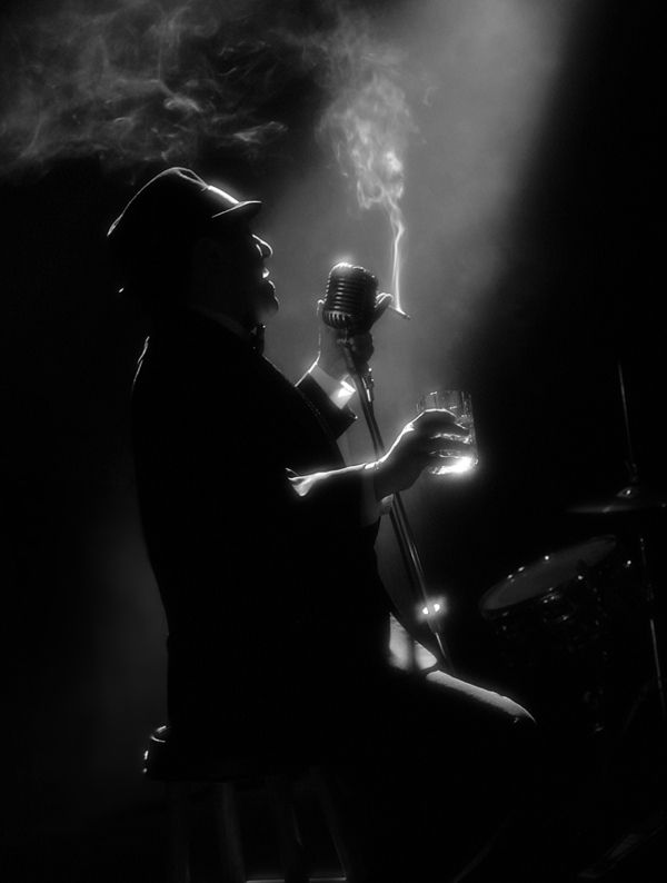 a man sitting in front of a microphone on top of a stage