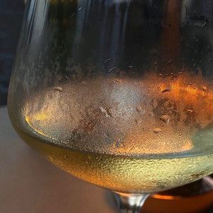 a glass filled with liquid sitting on top of a table