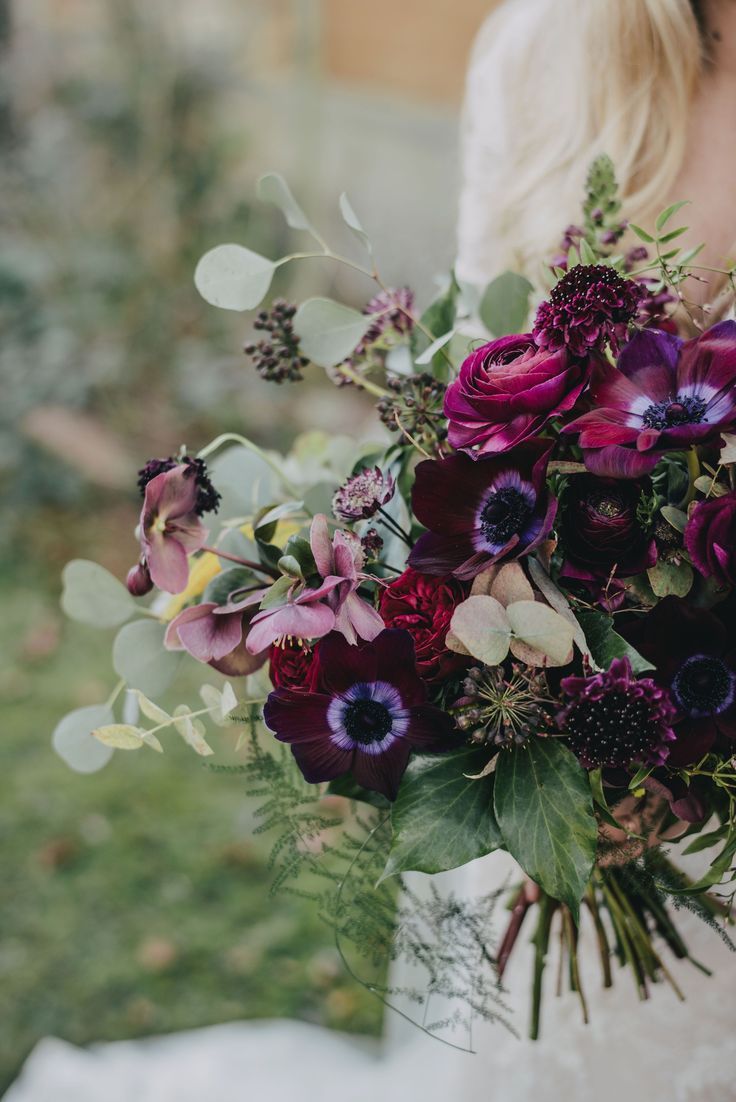 a woman holding a bouquet of flowers in her hands