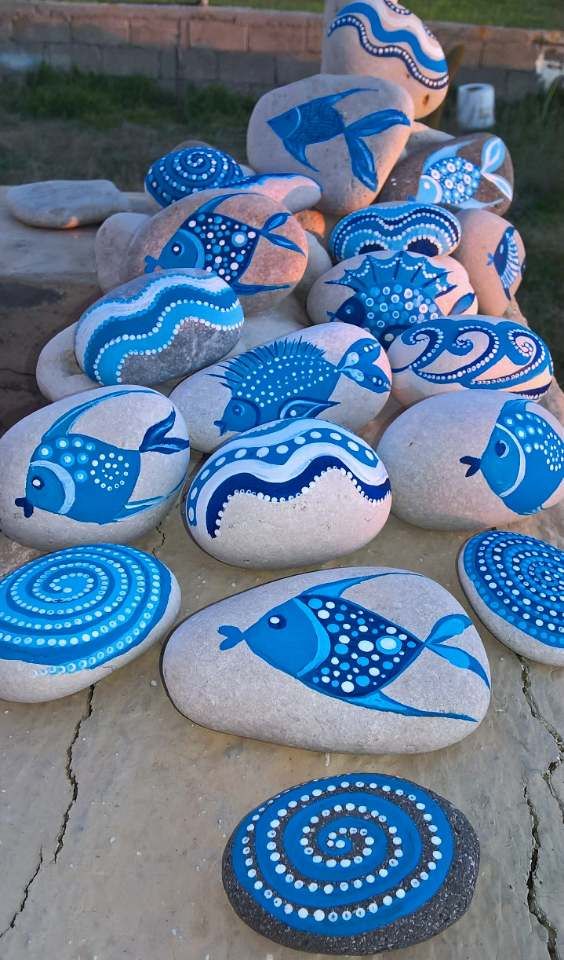 blue and white painted rocks with fish on them