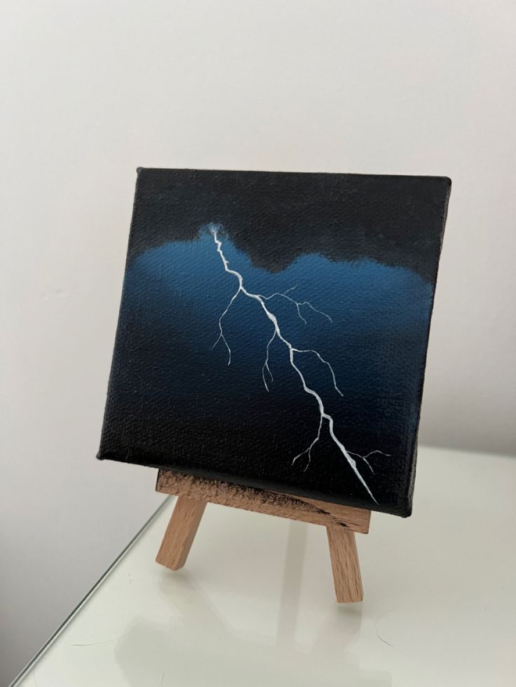 an easel with a painting on it that has a lightning bolt painted on it