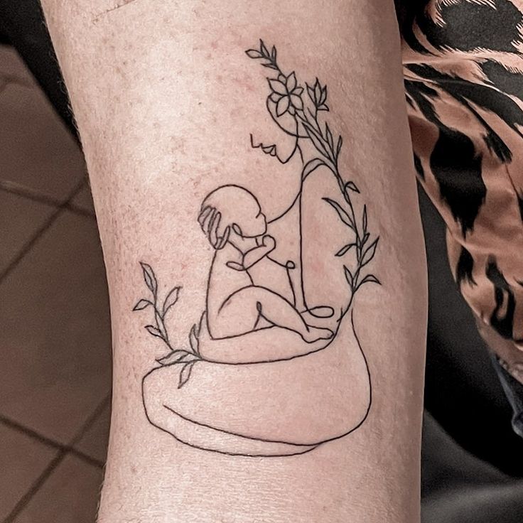 a person with a tattoo on their arm holding a plant and sitting in a boat