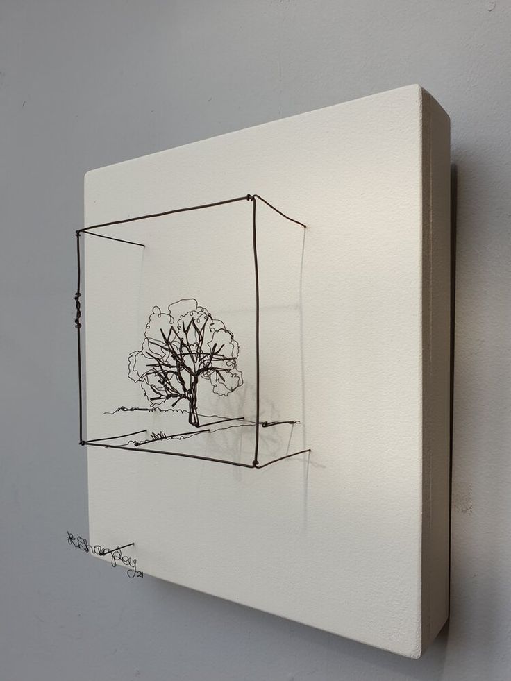 a drawing of a tree is hanging on the wall next to a white square frame