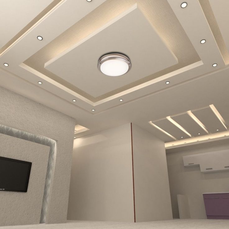 an empty room with a flat screen tv on the wall and recessed lighting in the ceiling