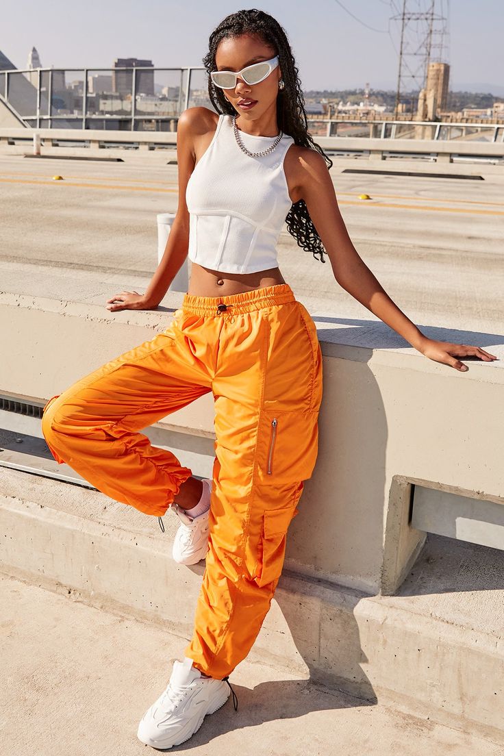 It’s giving off-duty vibes! Our Women's High-Rise Rouched Nylon Jogger is the perfect baggy pant to add to your wardrobe! Designed with an adjustable bungee cord at the elasticized waistband for the perfect fit and comfort. These high waisted pants are meant to be oversized with a baggy and slouchy fit. Featuring silver hardware and large cargo pockets for a sporty-chic vibe. We’ve also added adjustable bungee cords at the bottom hems to give you the option of wearing them more scrunched up at t Hip Hop Cargo Pants, Sporty Fashion, Ymi Jeans, Bungee Cords, Cargo Pants Outfit, Pics Inspo, Orange Outfit, Bungee Cord, Hip Hop Outfits