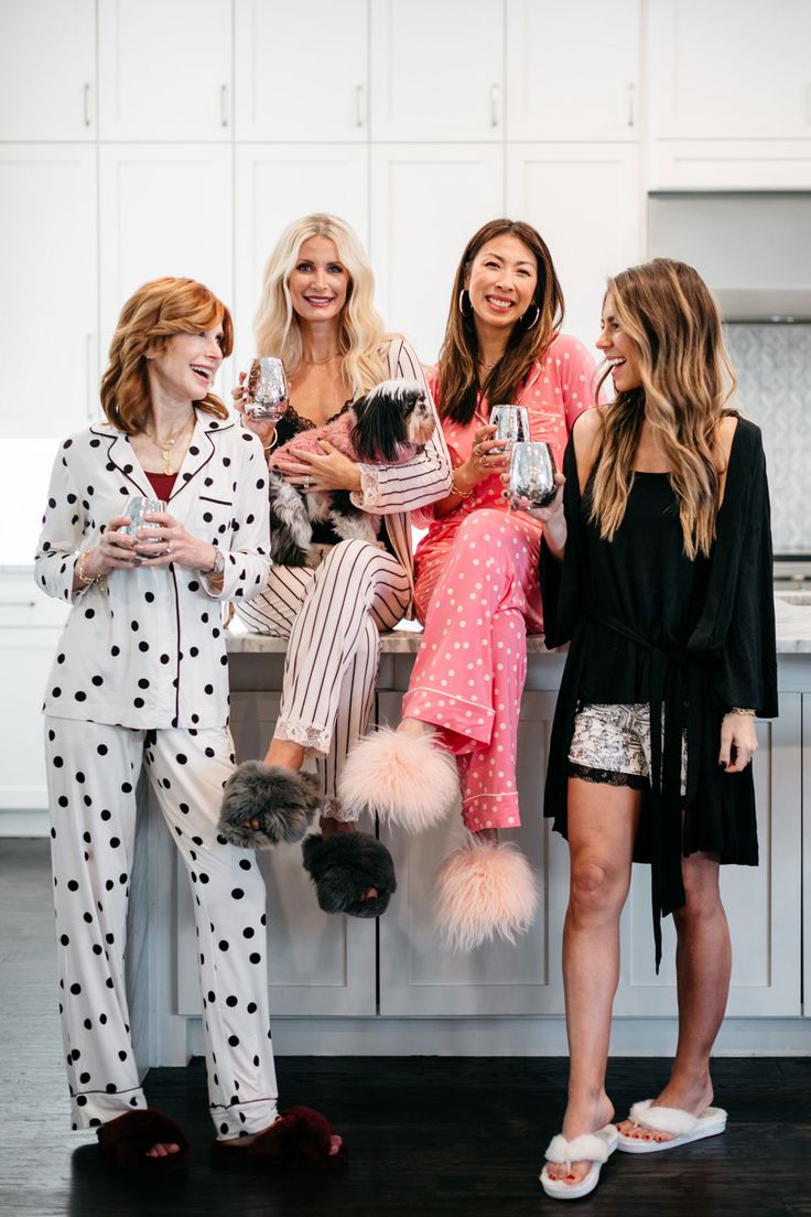 three women in pajamas are sitting on a counter