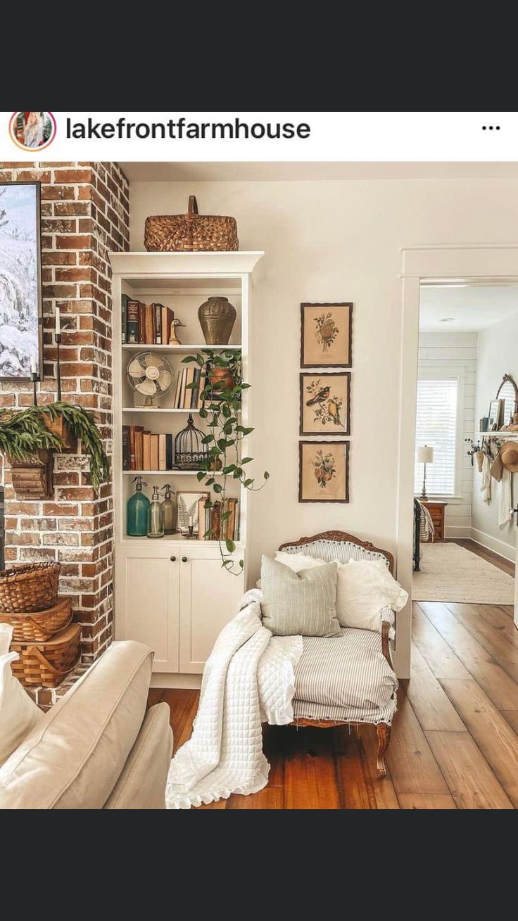 a living room filled with furniture and bookshelves next to a brick fire place