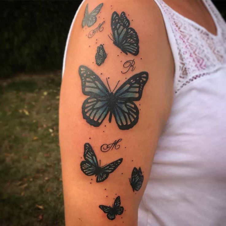 a woman's arm with butterflies on it and the word love written in cursive writing