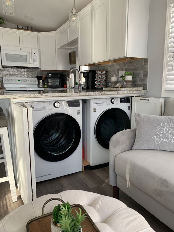 a living room filled with furniture and a washing machine in front of a counter top oven