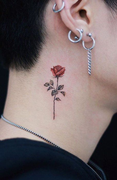 a woman's neck with a rose tattoo on her left side behind the ear