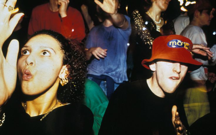 a group of people standing next to each other with their hands up in the air