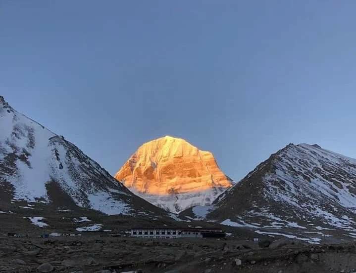 the mountains are covered in snow as the sun sets