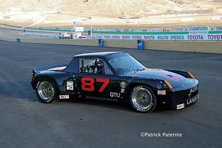 a black sports car with red numbers on it's side in a parking lot