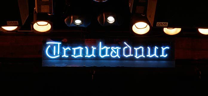 there is a neon sign that says turntableour on the side of a building