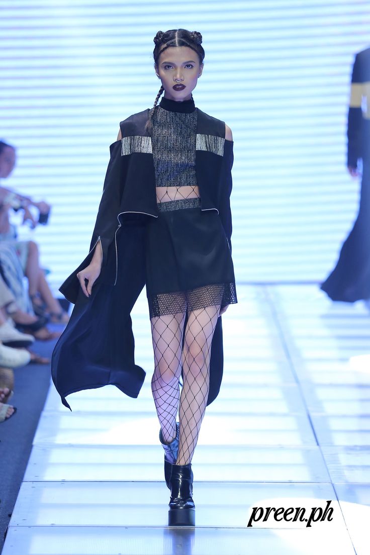 a woman walking down a runway wearing fishnet stockings