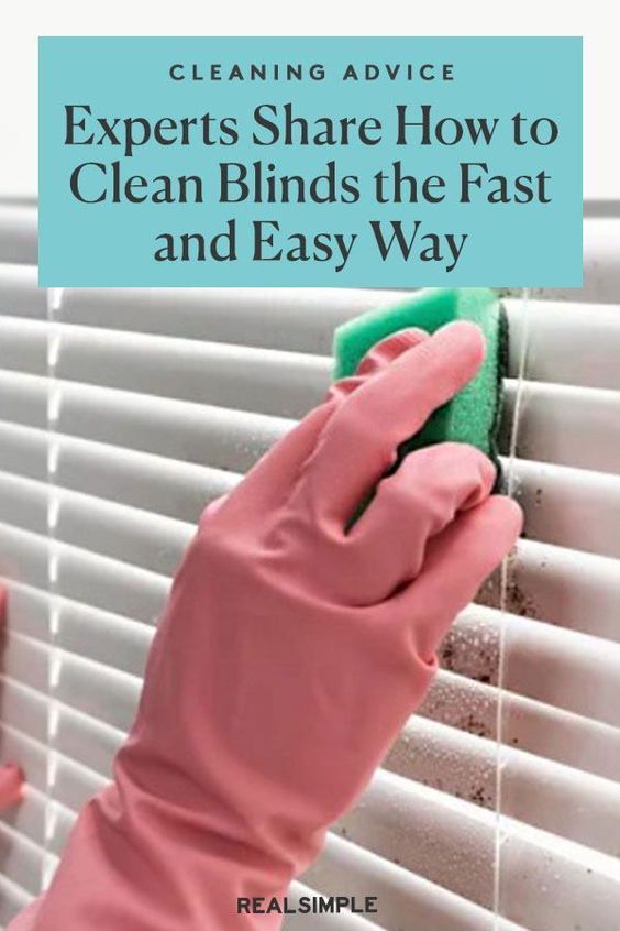 a person in pink gloves cleaning the blinds