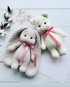 two crocheted stuffed animals sitting next to each other on top of a table