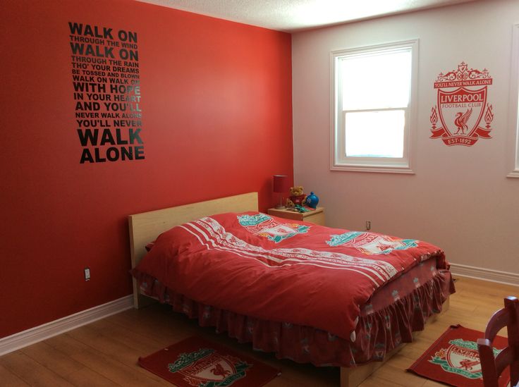 a bedroom with red walls and wooden floors