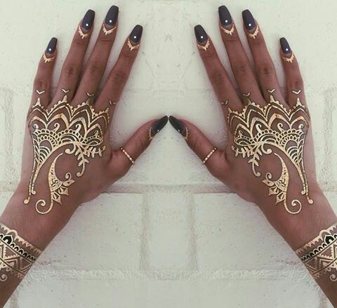 two hands with henna tattoos on them