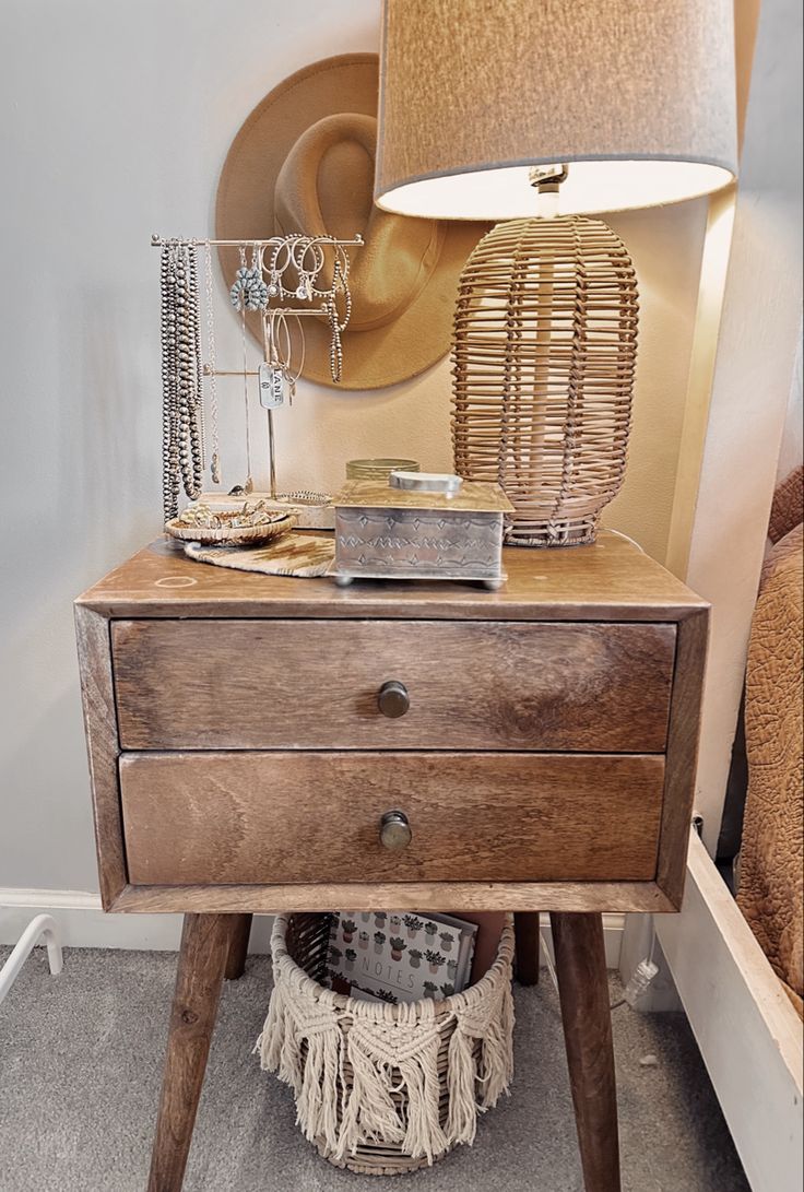 a wooden table with a lamp on top of it next to a basket and other items