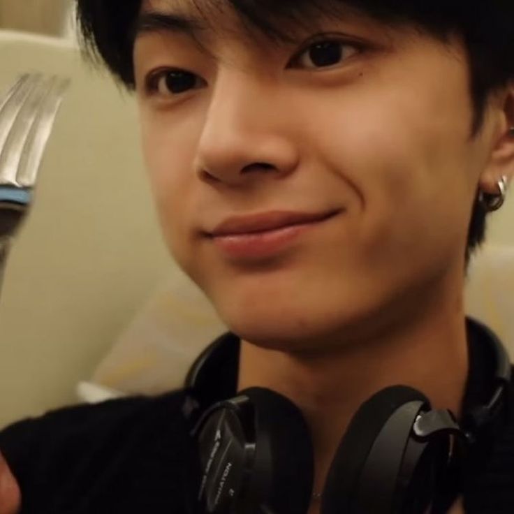 a man with headphones holding a fork and knife